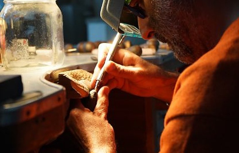 Un orafo al lavoro al banco nel laboratorio Conti Gioielli